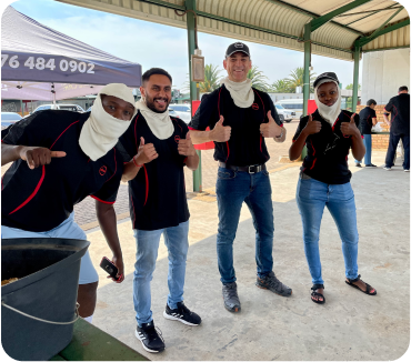 4 racers all giving thumbs up to the camera at a public track day event