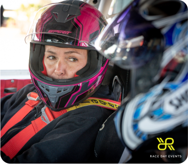 Two drivers looking at each other in the driver's seat of a racing car